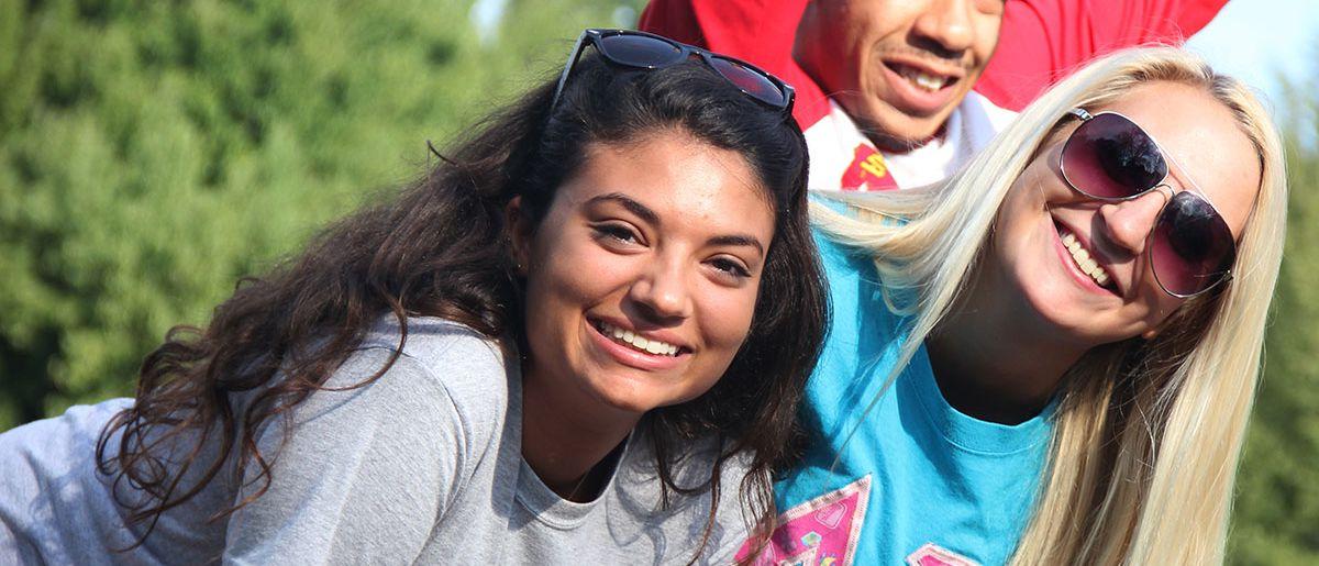 Three students look at and smile at the camera.